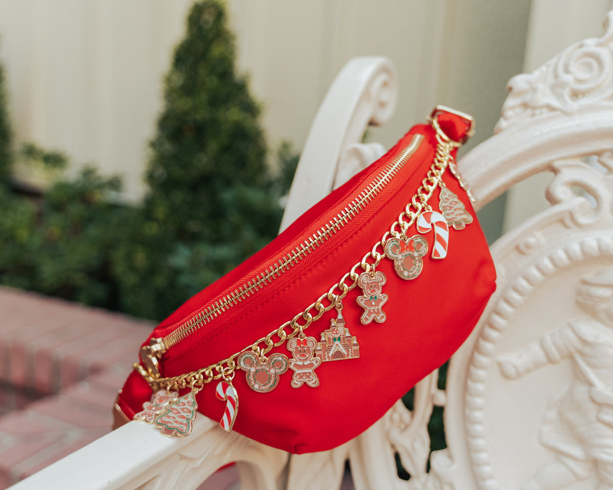 Red fanny pack with gold charms on a decorative chair