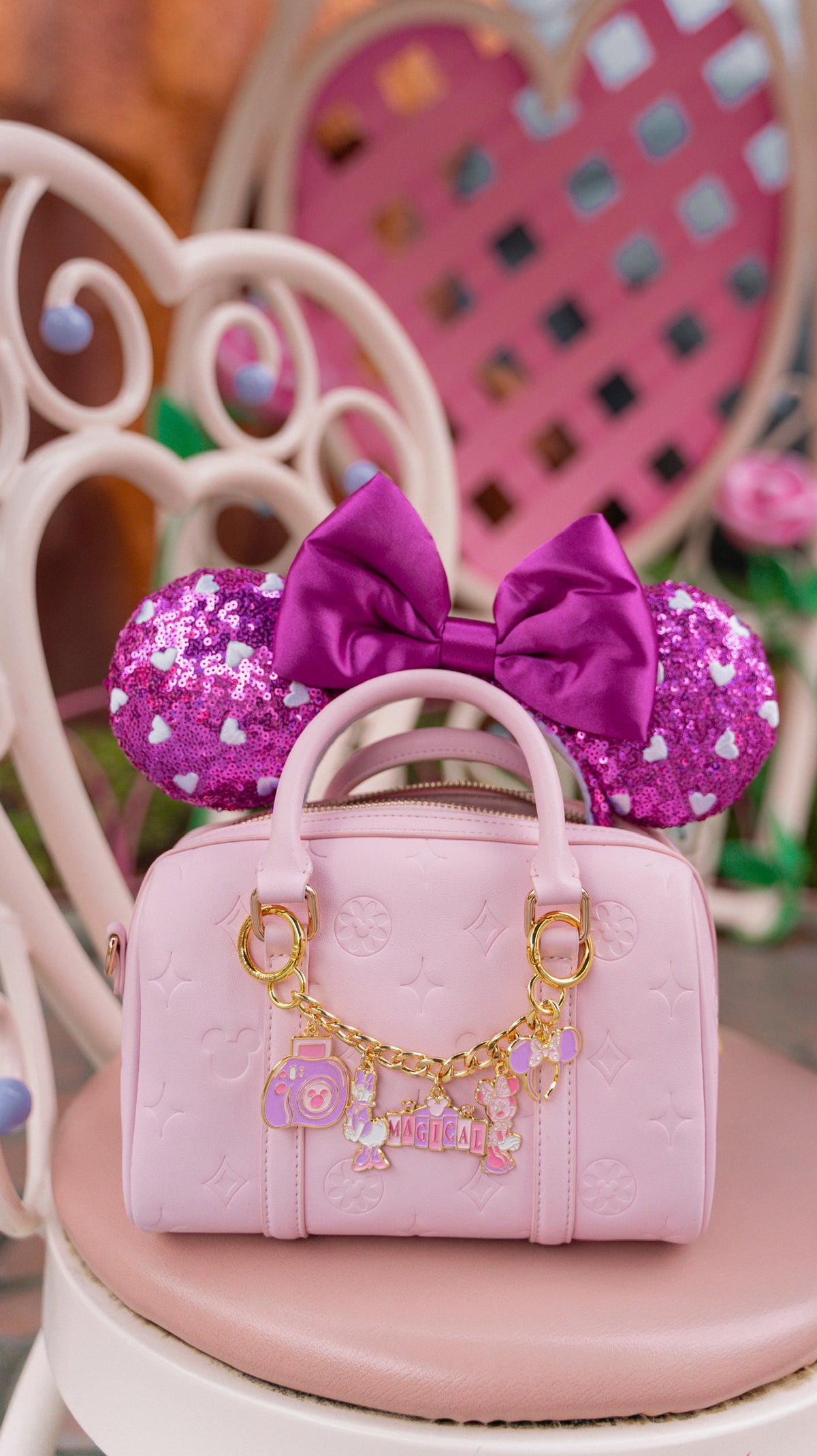 Pink handbag with decorative bow and polka dot design on a chair.