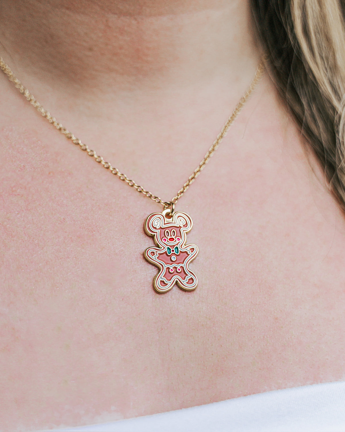 Necklace with a pink teddy bear pendant on a person's neck